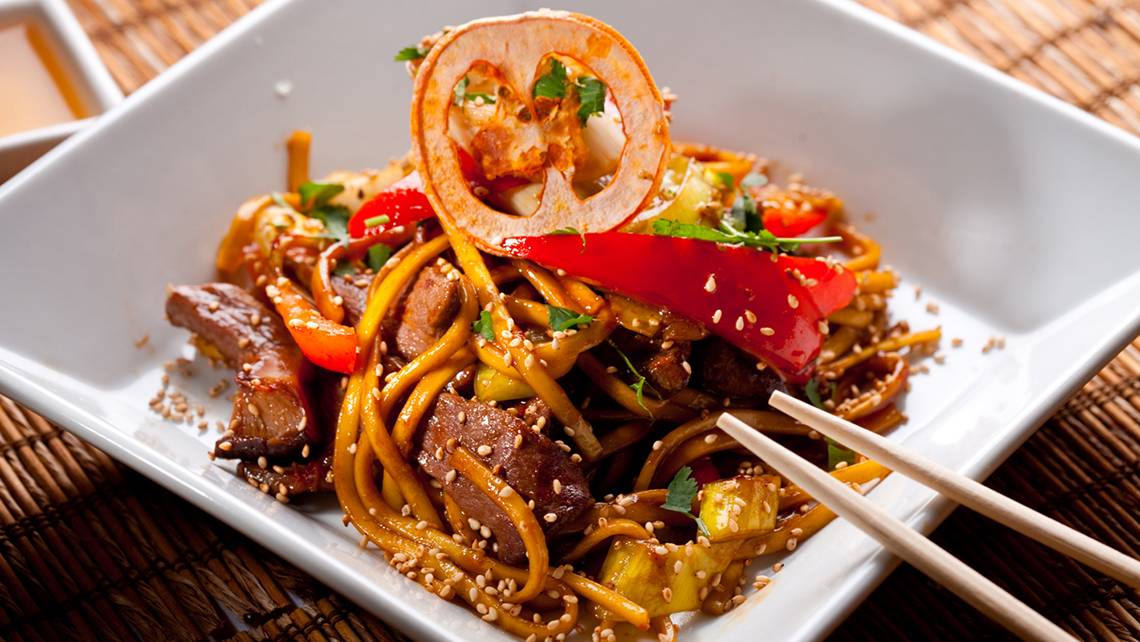 Asiatische Nudeln mit Gewürzen in einem Teller mit Chopsticks