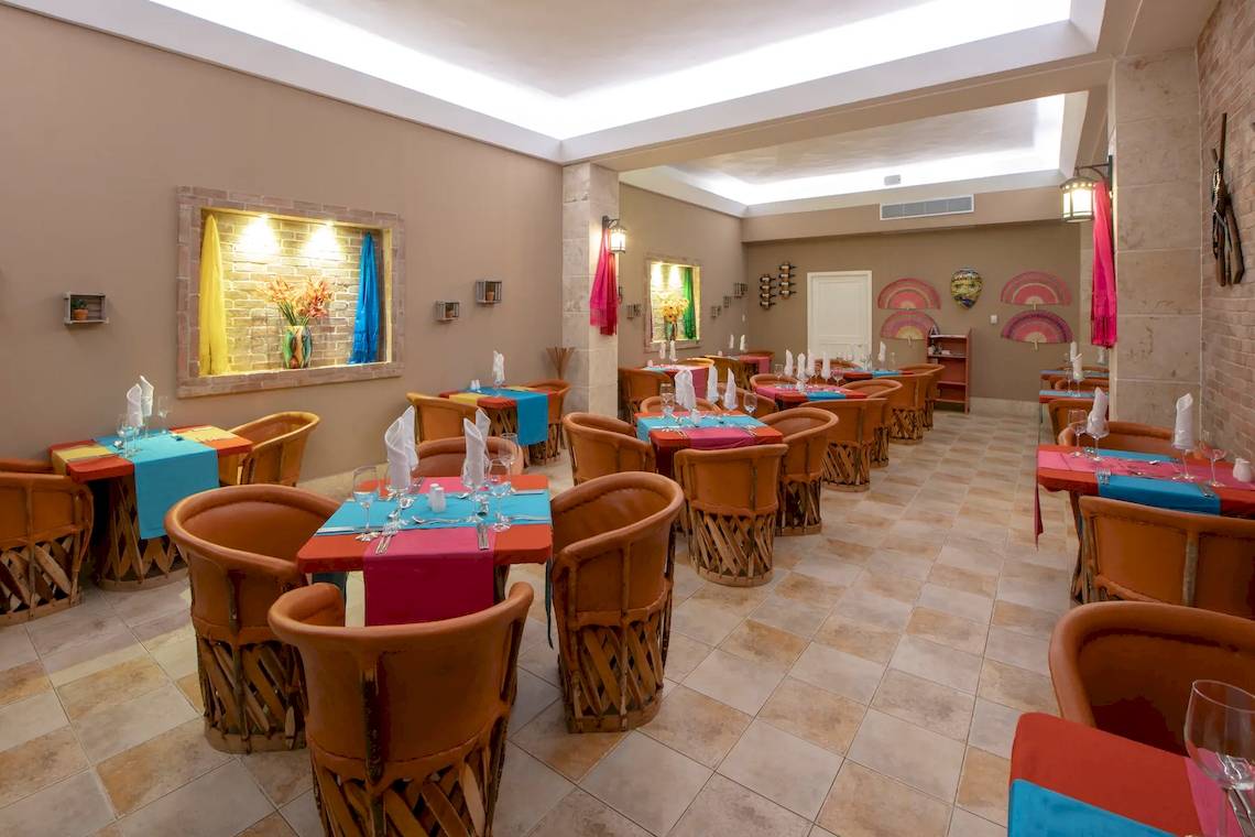Innenansicht des Viva Wyndham V Heavens Restaurants mit braunen Stühlen und blauen Tischdecken.