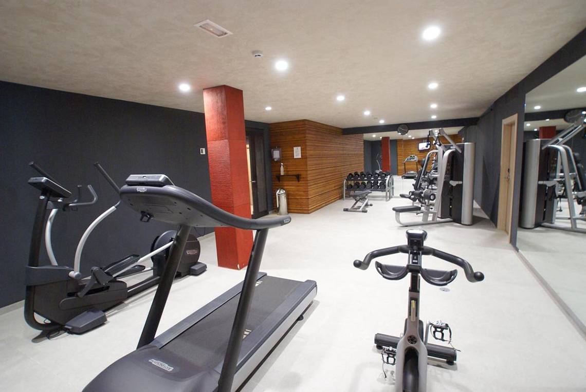Fitnessbereich im Hotel Riviera Vista mit Laufband, Ellipsentrainer und Gewichtsbank.