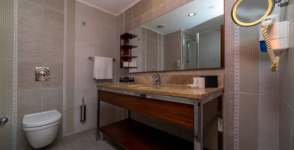 Badezimmer im Kamelya Aishen K Club Hotel mit Waschbecken, Spiegel und Toilette