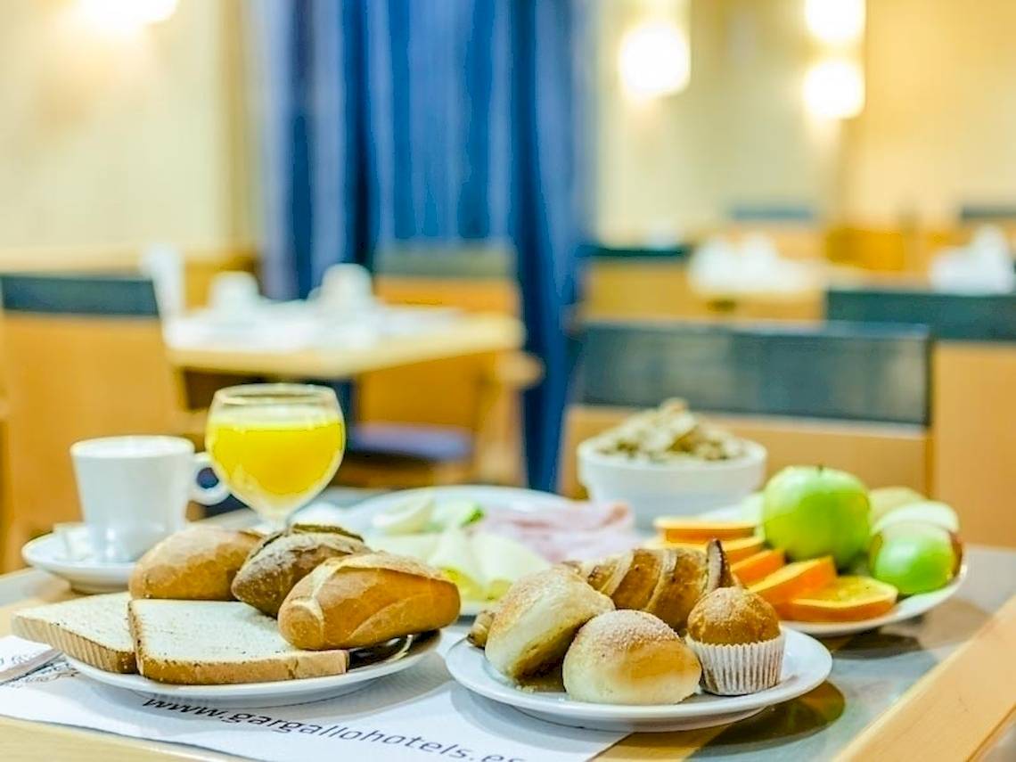Frühstücksbuffet im Hotel Del Mar in Barcelona mit Brot, Obst und Getränken.