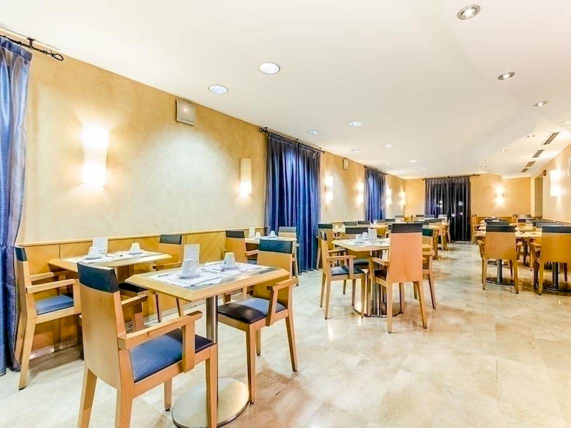 Restaurant im Del Mar - Barcelona Hotel mit gedeckten Tischen und Stühlen.