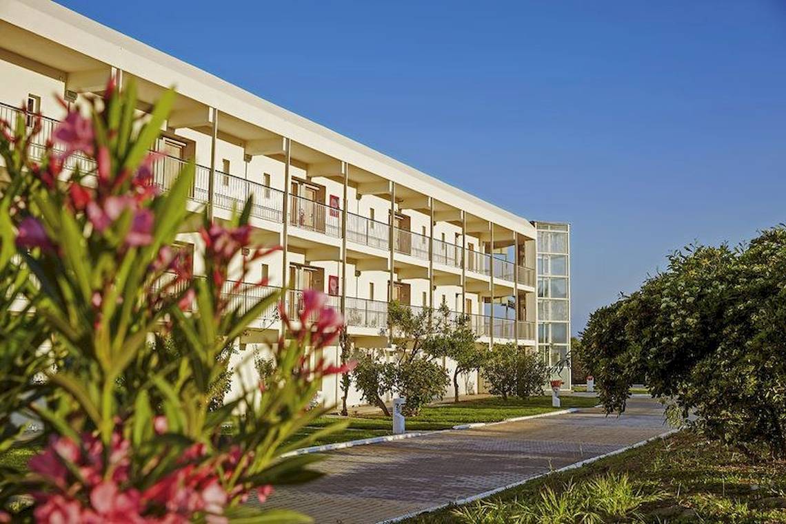 Außenansicht des Robinson Kyllini Beach Hotels mit Gebäuden, Balkonen und Pflanzen.