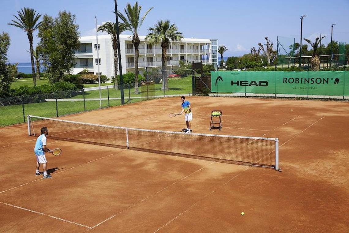Tennisplatz im Robinson Kyllini Beach Hotel mit zwei Spielern und einem Trainer.