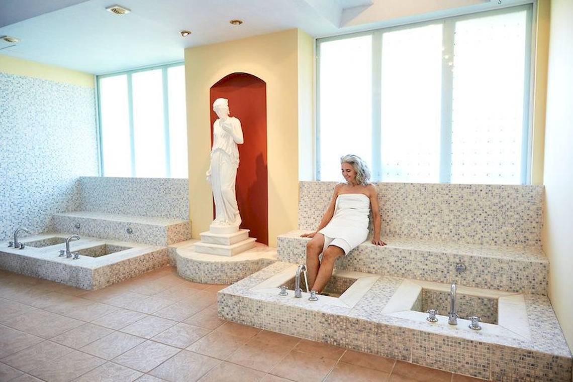 Frau in Saunabereich des Robinson Kyllini Beach Hotels mit Statue im Hintergrund