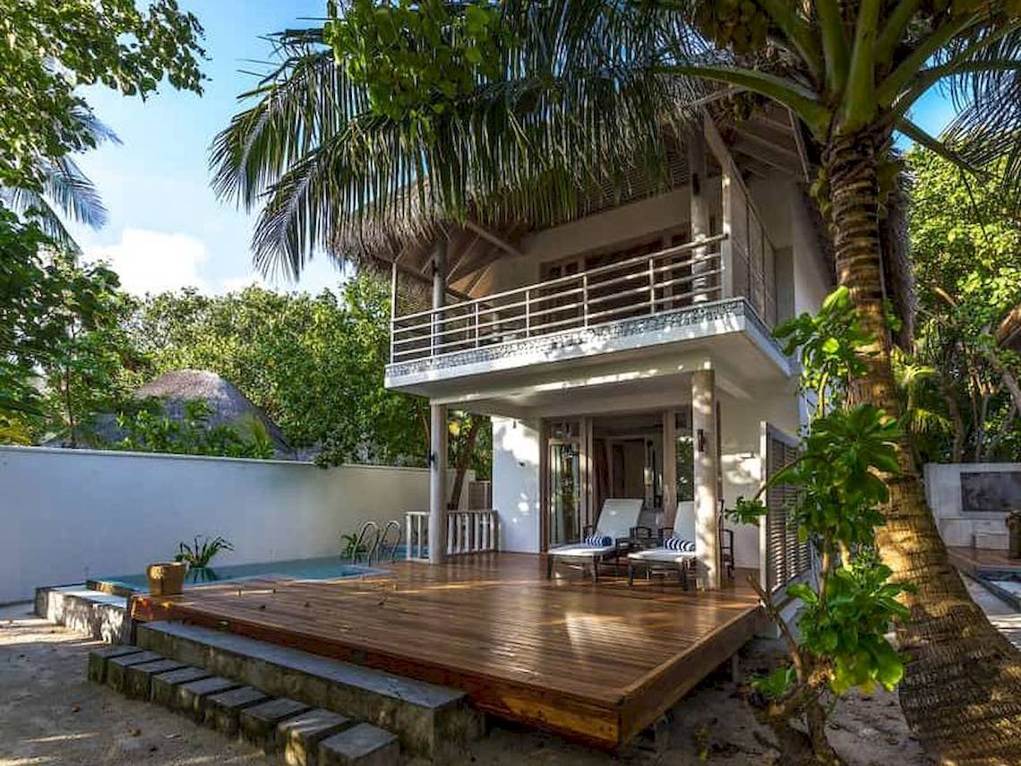 Villa des Amaya Kuda Rah Hotels mit Pool, Holzterrasse und Liegestühlen.