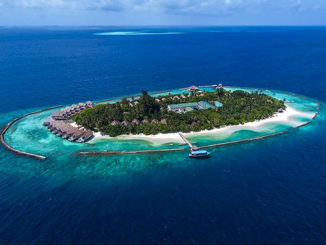 Luftaufnahme des Amaya Kuda Rah Hotels, eine Insel mit mehreren Bungalows und einem Steg