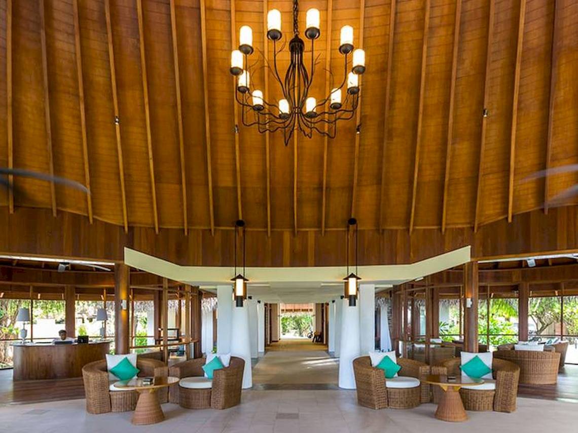 Innenbereich des Amaya Kuda Rah Hotels mit einem großen Kronleuchter und bequemen Sesseln.