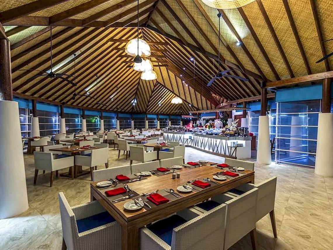 Innenansicht des Restaurants des Amaya Kuda Rah Hotels mit gedeckten Tischen und Stühlen.