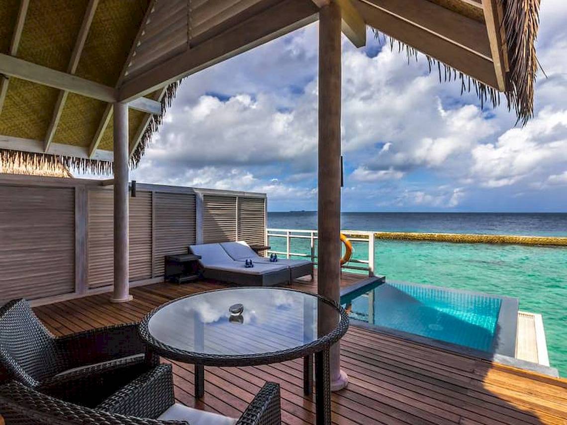 Balkon des Amaya Kuda Rah Hotels mit Blick auf das Meer und Sonnenliegen.