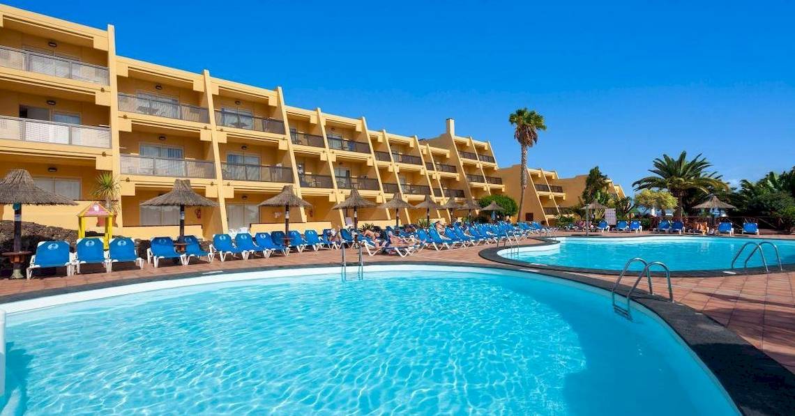 Außenpool des Sol Fuerteventura Jandia Hotels mit blauen Sonnenliegen und Palmen