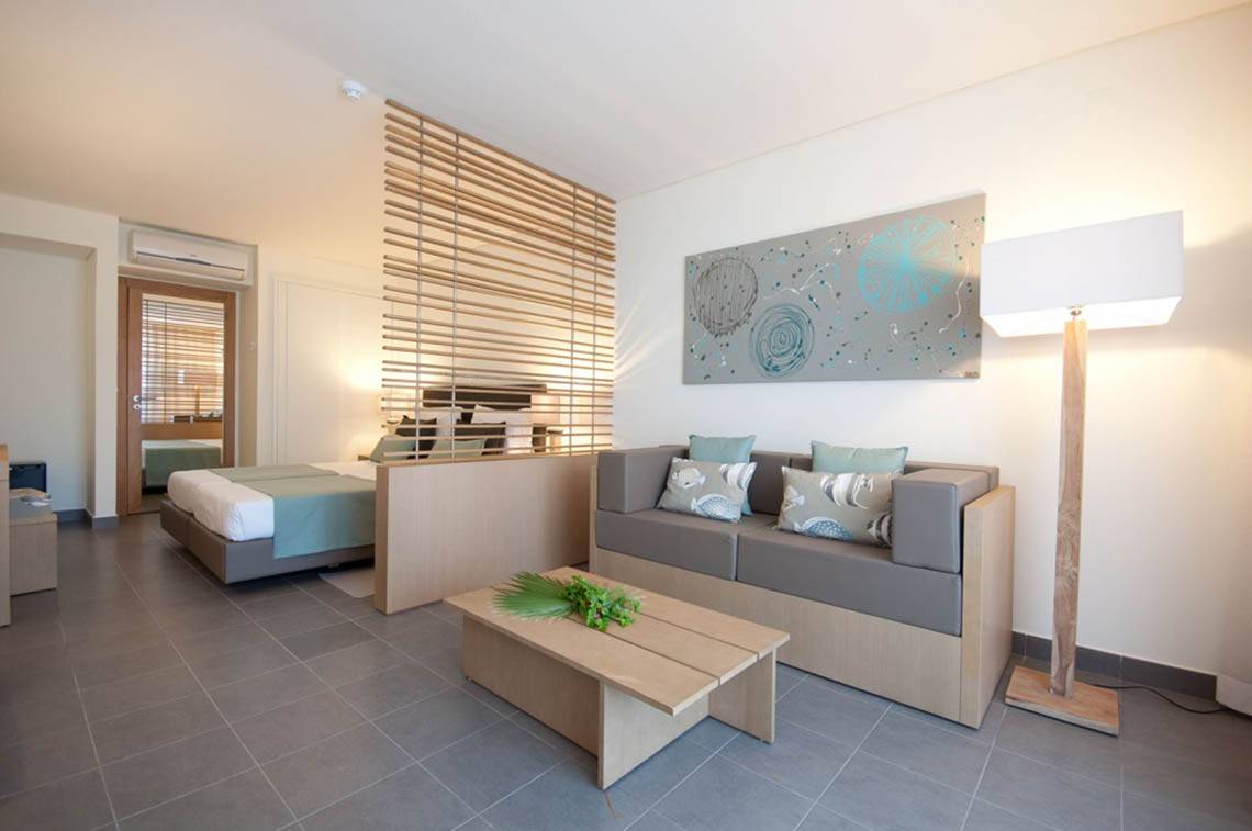Innenansicht des Oasis Salinas Sea Hotel Zimmers mit einem Bett und einem Sofa.