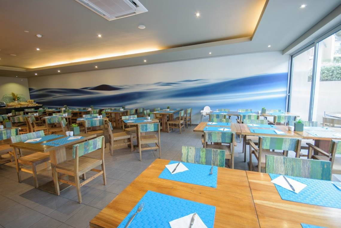 Innenansicht des Restaurants im Oasis Salinas Sea Hotel mit blauem Meereswandbild.