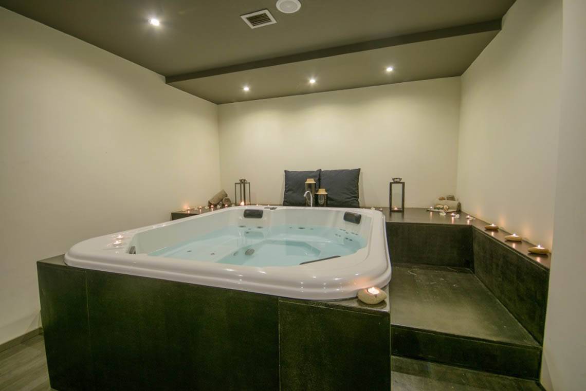 Jacuzzi im Oasis Salinas Sea Hotel, umgeben von Kerzen und Kissen.