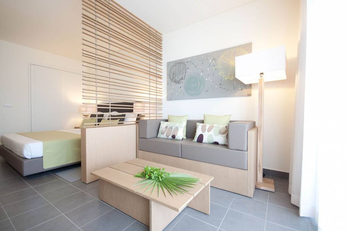 Innenansicht eines Schlafzimmers im Oasis Salinas Sea Hotel mit Bett, Sofa und Wohnzimmermöbeln.