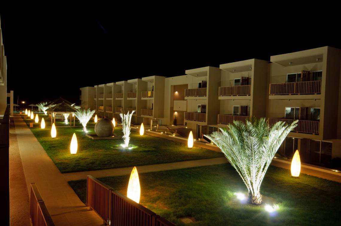 Nachtansicht des Oasis Salinas Sea Hotels mit beleuchteten Palmen und Gebäuden