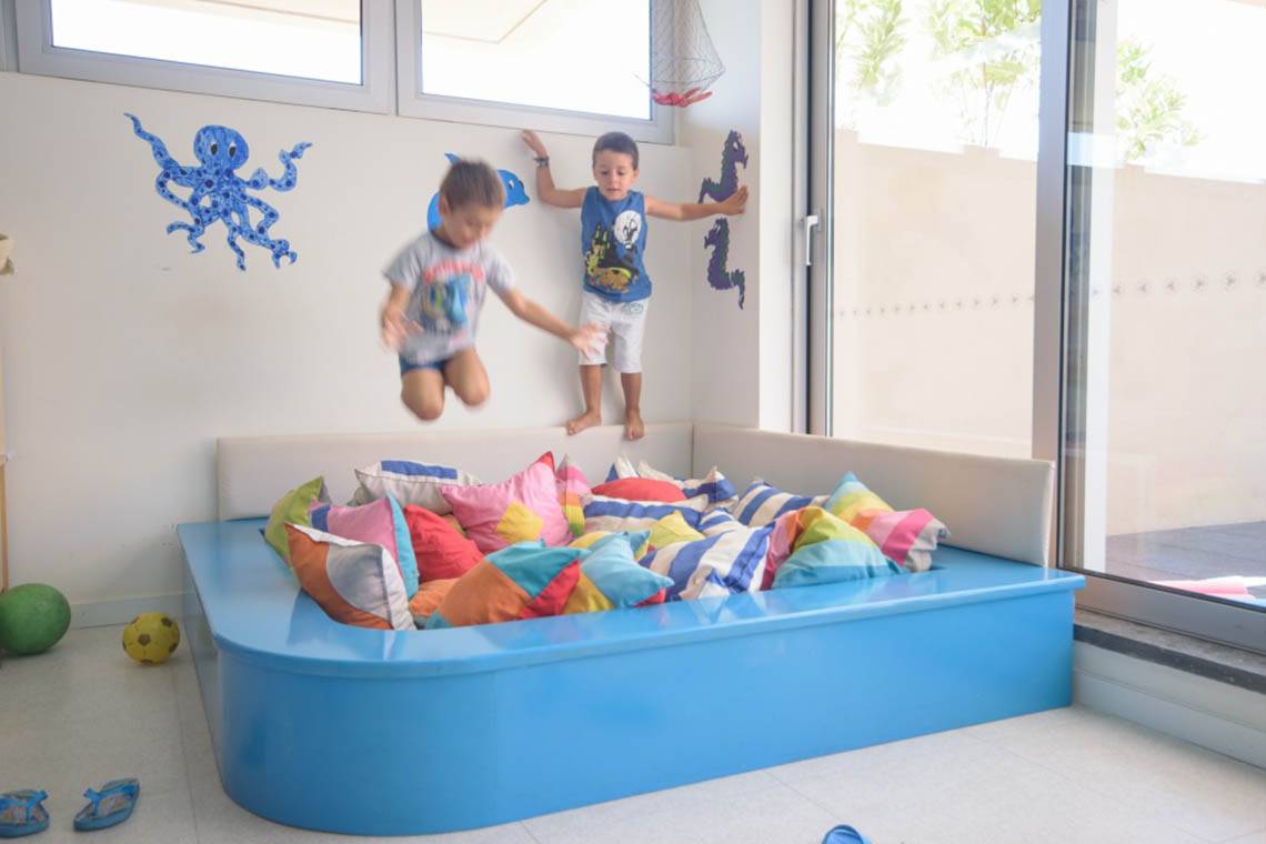 Zwei Kinder springen in einem blauen Kissenpool in einem Zimmer des Oasis Salinas Sea Hotels.