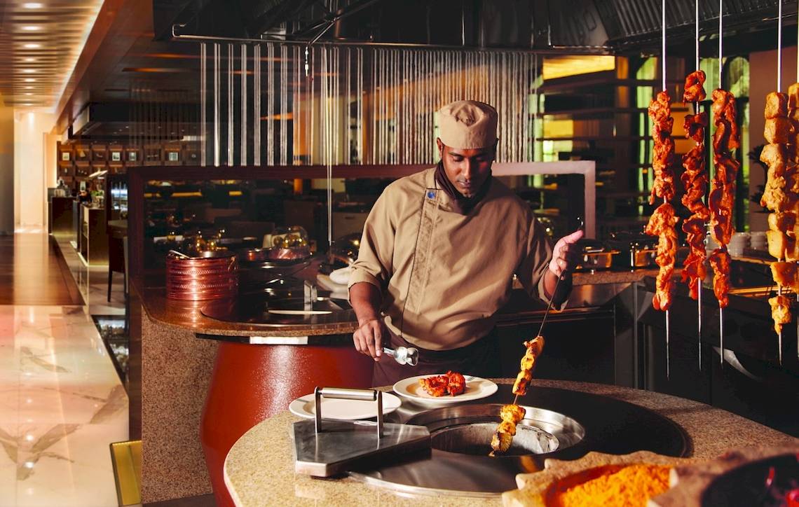 Koch im Al Ain Rotana Hotel, der im Restaurant würzige Fleischspieße grillt.