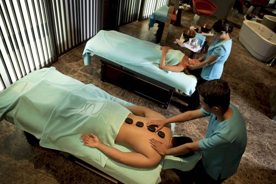 Massagebehandlung im Al Ain Rotana Hotel mit zwei Therapeuten und Kunden.