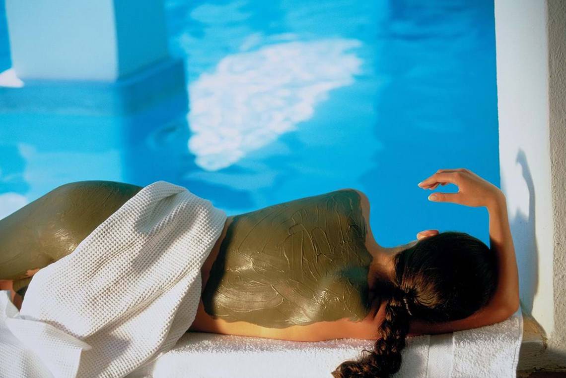 Frau mit Moorpackung am Pool des Elounda Beach Hotel & Villas