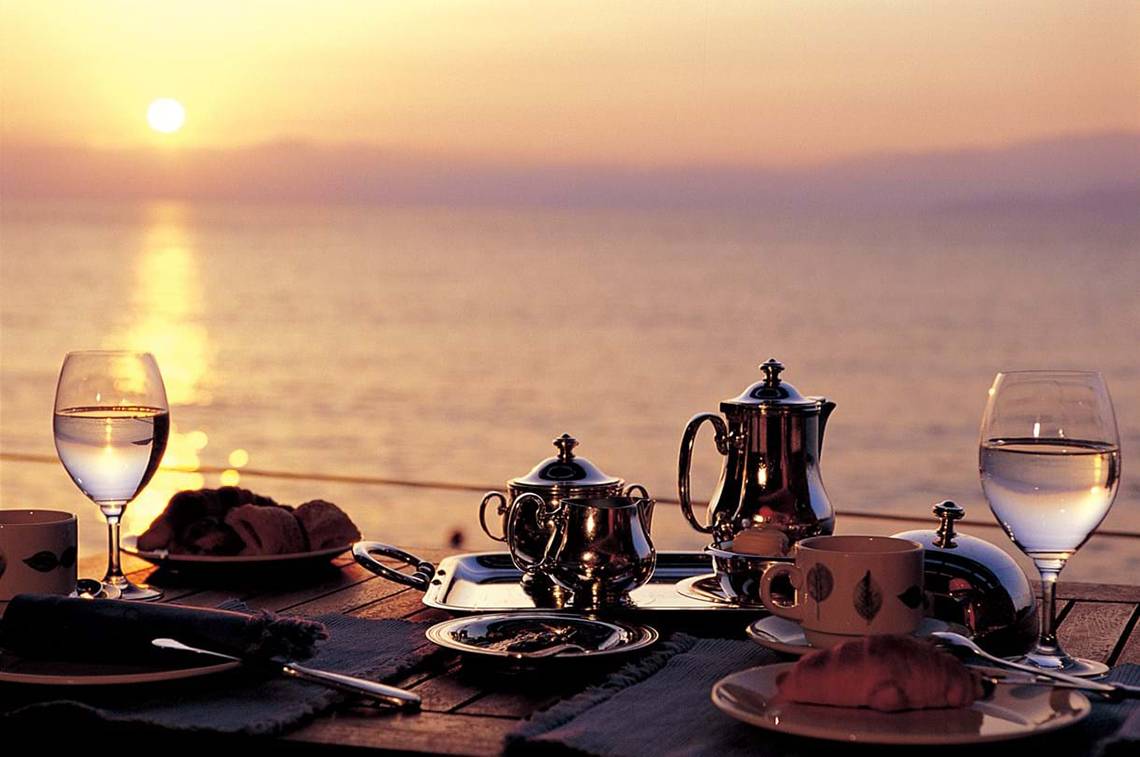 Abendessen am Strand im Elounda Beach Hotel mit Blick auf den Sonnenuntergang.