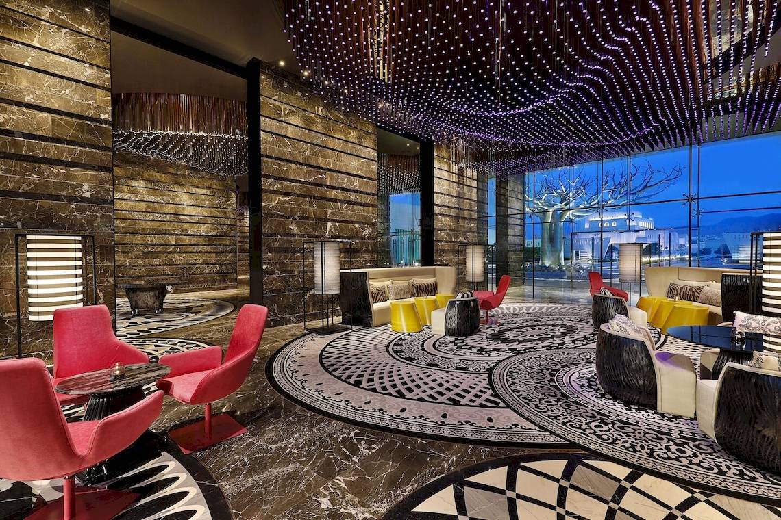 Lobby des W Muscat Hotels mit modernen Möbeln und Marmorboden
