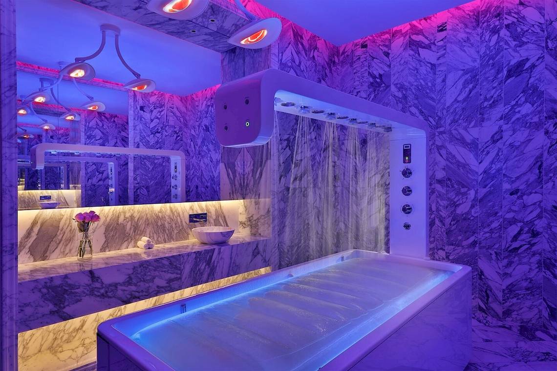 Modernes Badezimmer mit violetten LED-Lichtern und Marmorwänden im W Muscat Hotel.