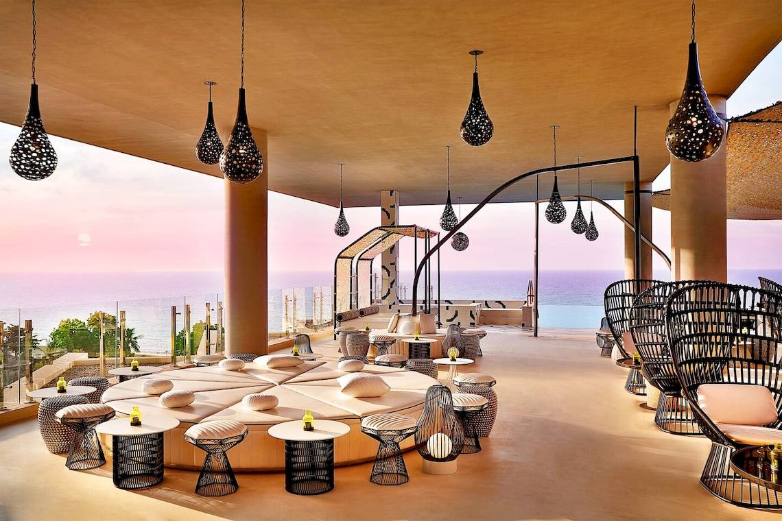 Loungebereich des W Muscat mit Blick auf das Meer und moderne Beleuchtung.