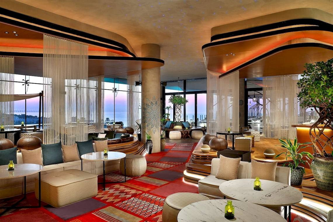 Lounge-Bereich des W Muscat Hotels mit modernen Möbeln und Aussicht auf das Meer.
