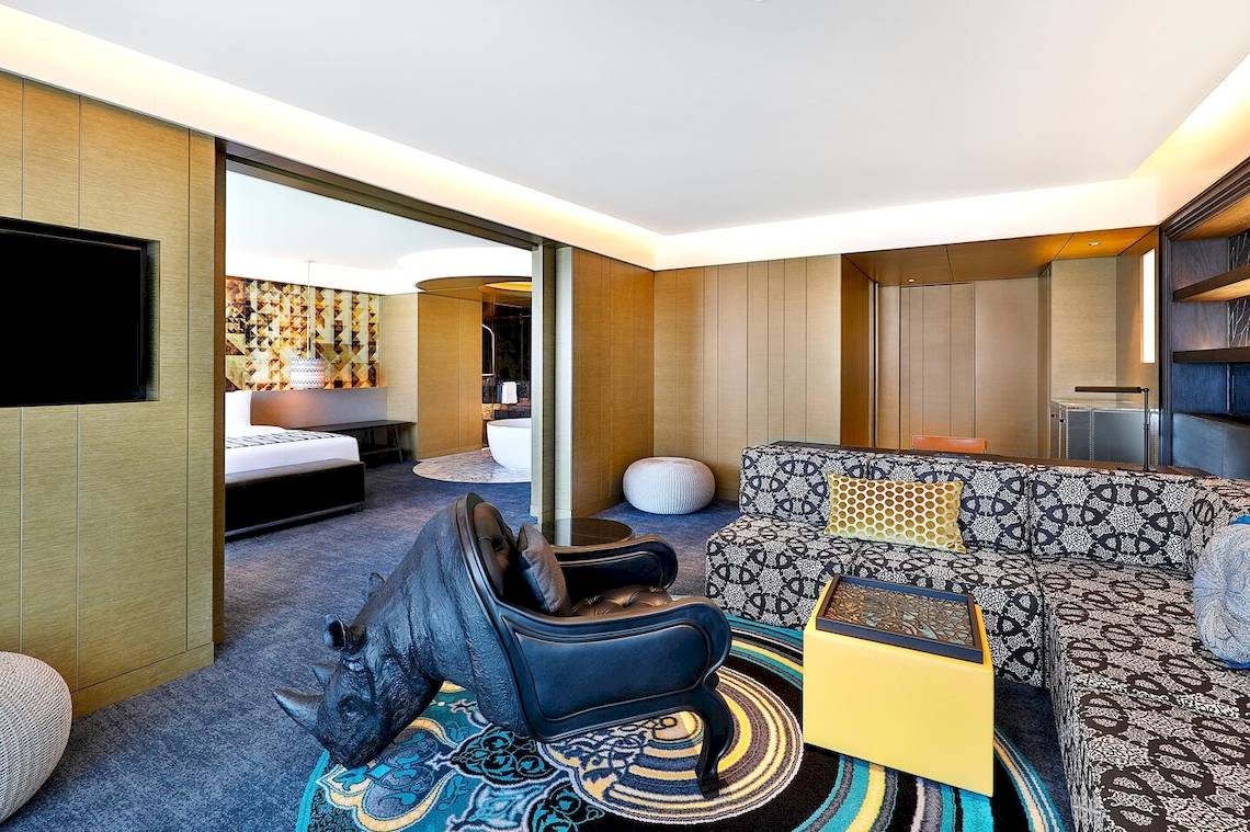 Innenansicht der Suite im W Muscat Hotel mit afrikanischem Rhino-Dekor, modernen Möbeln und offenem Badezimmerbereich.