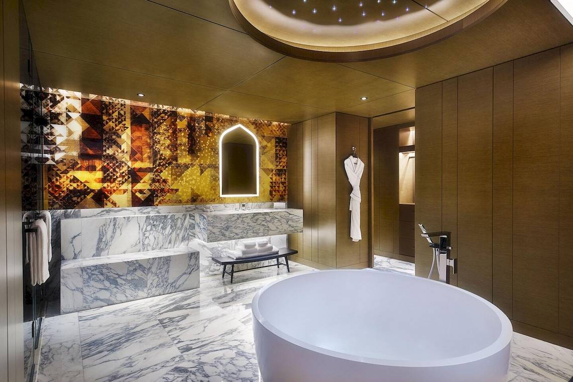 Badezimmer des W Muscat Hotels mit marmorboden und doppelwaschbecken