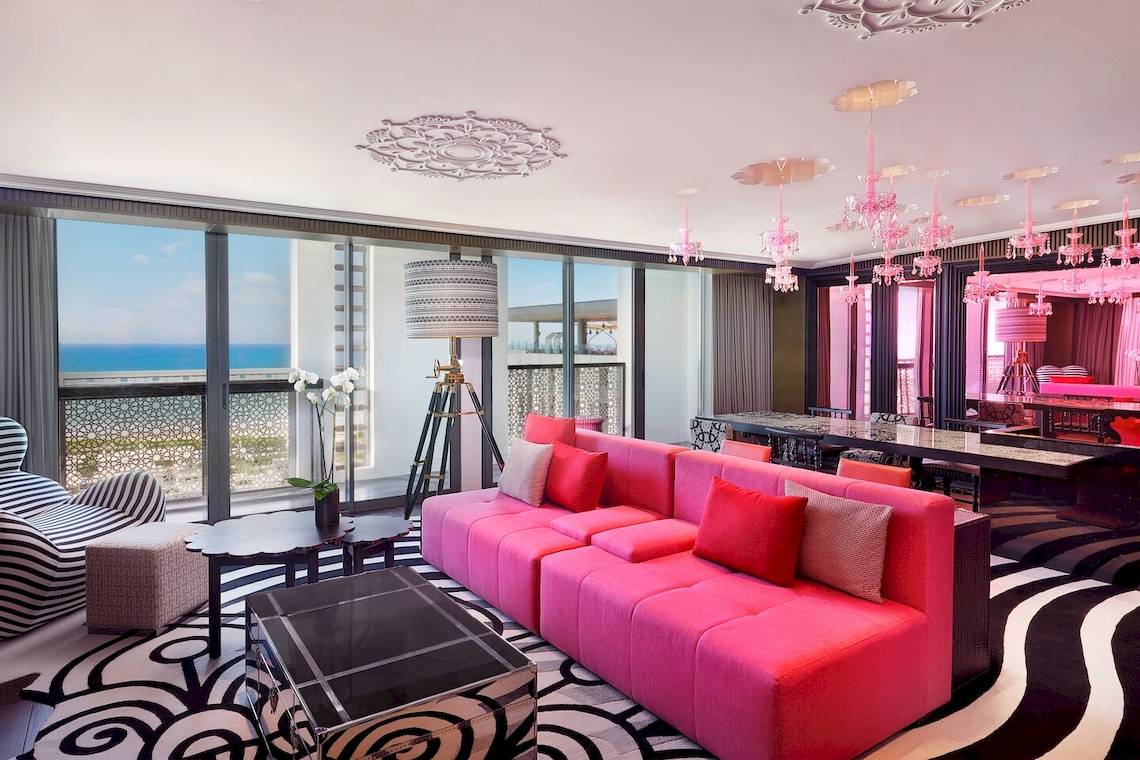 W Muscat Hotel Innenraum mit rosa Sofa und schwarzem Teppich