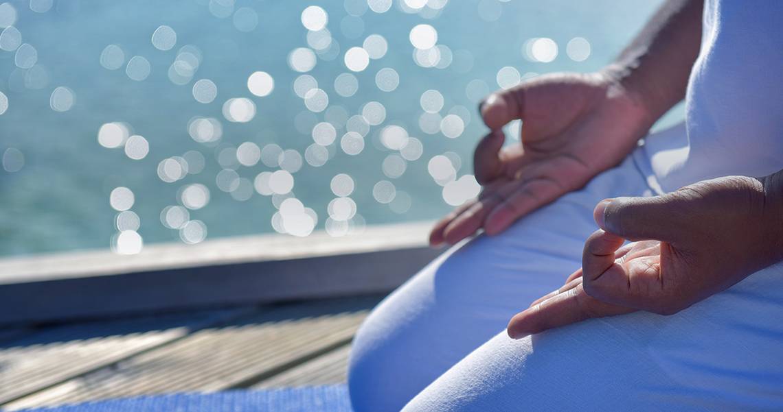 Person in Yoga-Pose am Meer, Velassaru Maldives