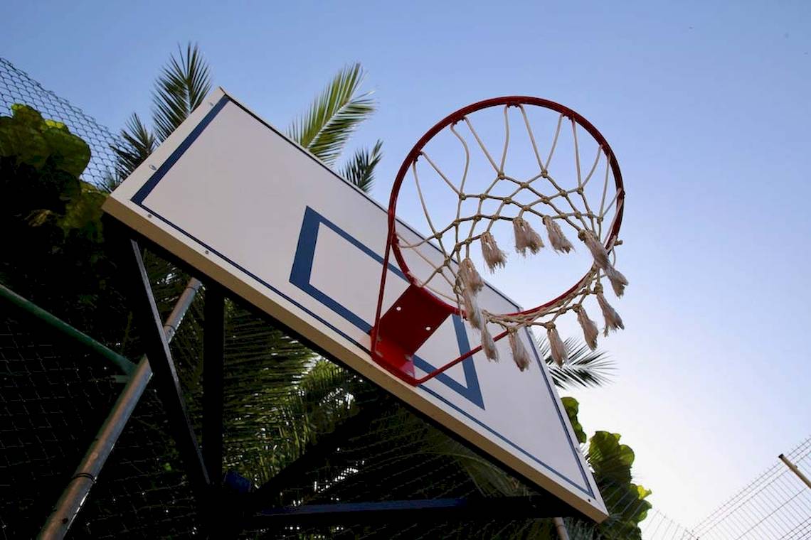 Basketballkorb im Freien mit Korbnetz, das in einem blauen Himmel hängt