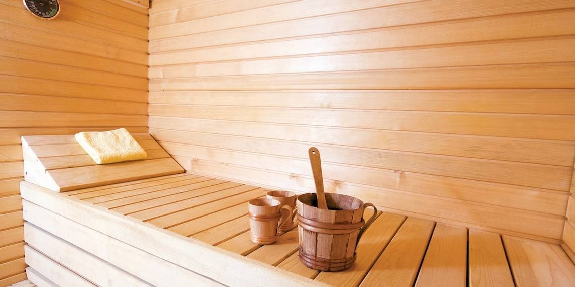Saunaraum im Remisens Hotel Albatros mit Holzbänken, Handtüchern und Holzeimern.