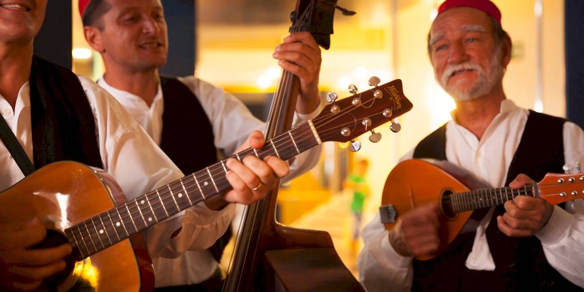 Drei Musiker spielen im Remisens Hotel Albatros Gitarre, Bass und Mandoline.