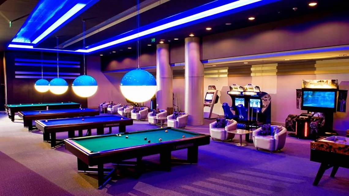 Spielzimmer im Gloria Verde Resort mit Billardtischen, Spielkonsolen und Sitzmöbeln.
