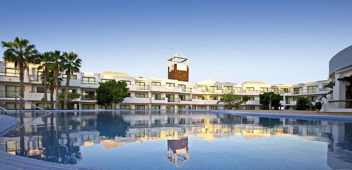 Außenpool des Be Live Experience Lanzarote Beach Hotels mit Palmen und Gebäude im Hintergrund