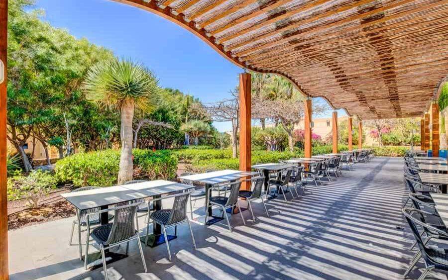Terrasse des SBH Taro Beach Hotels mit Tischen und Stühlen unter einem Baldachin