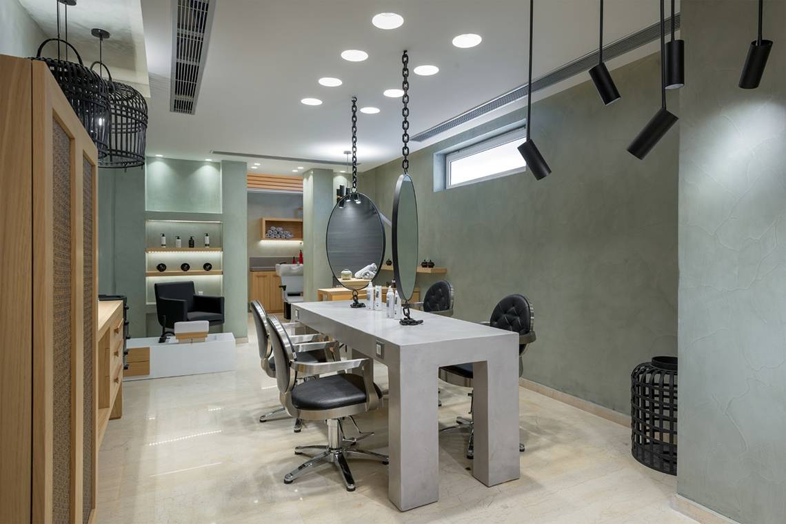 Friseursalon im Olympic Palace Resort mit langem Tisch und Stühlen.