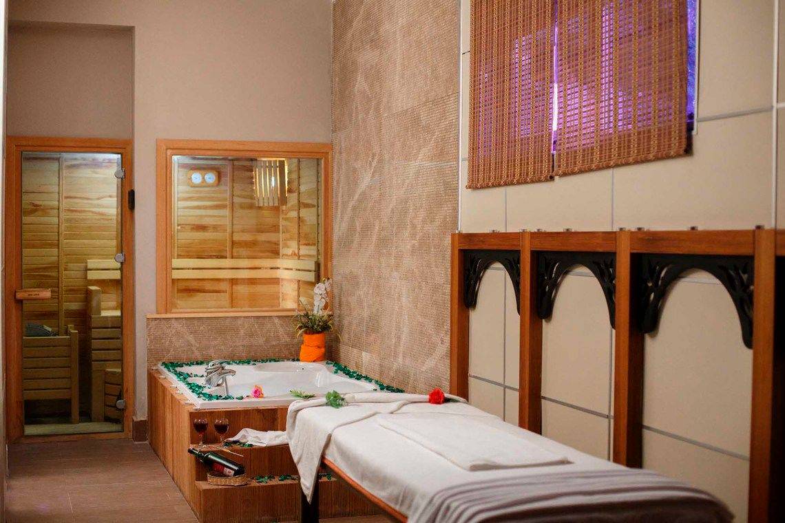 Spa-Behandlungsraum im Side Crown Palace mit Jacuzzi und Massageliege.