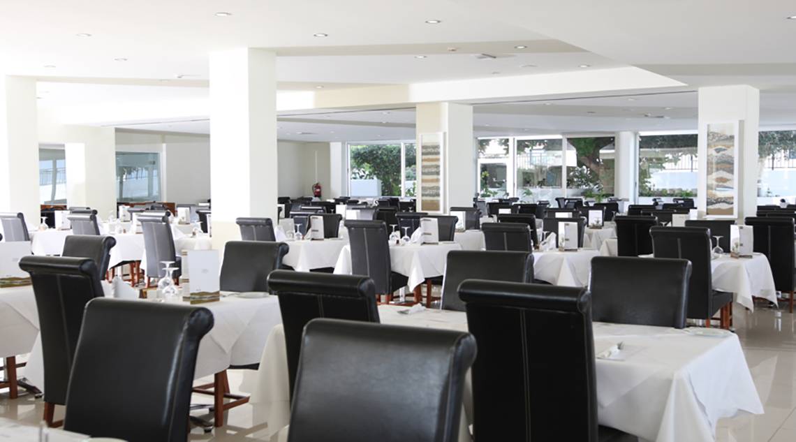 Restaurant des Vrissiana Beach Hotels mit vielen Tischen und Stühlen