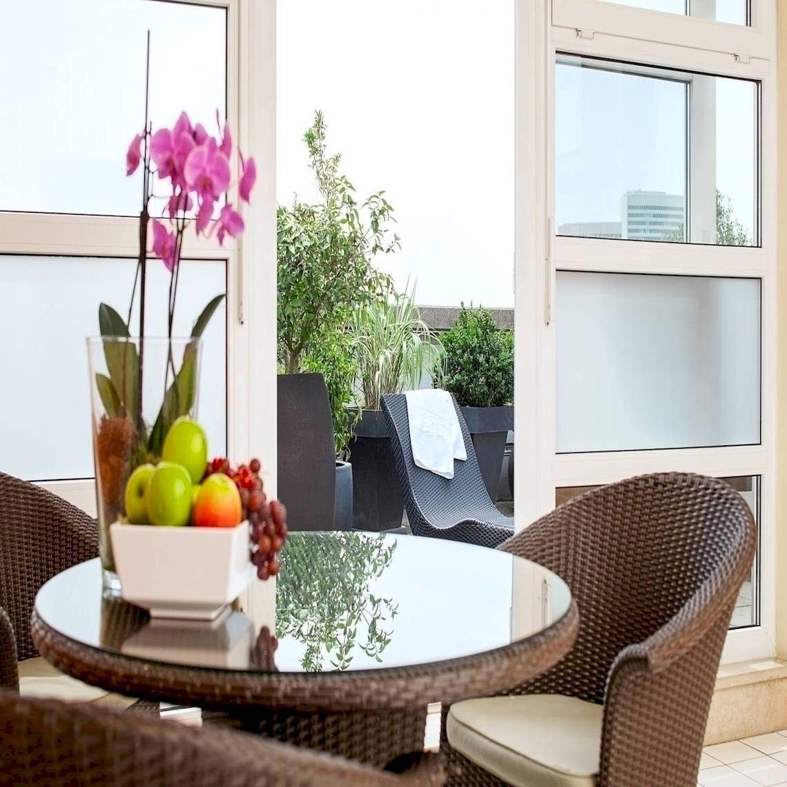 NH Hamburg Altona Hotel Innenraum mit Terrassenmöbeln und Obstschüssel