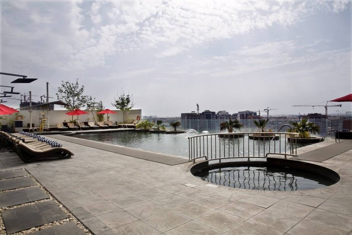 Pool-Terrasse mit Liegen und roten Sonnenschirmen im Tower Plaza Hotel Dubai
