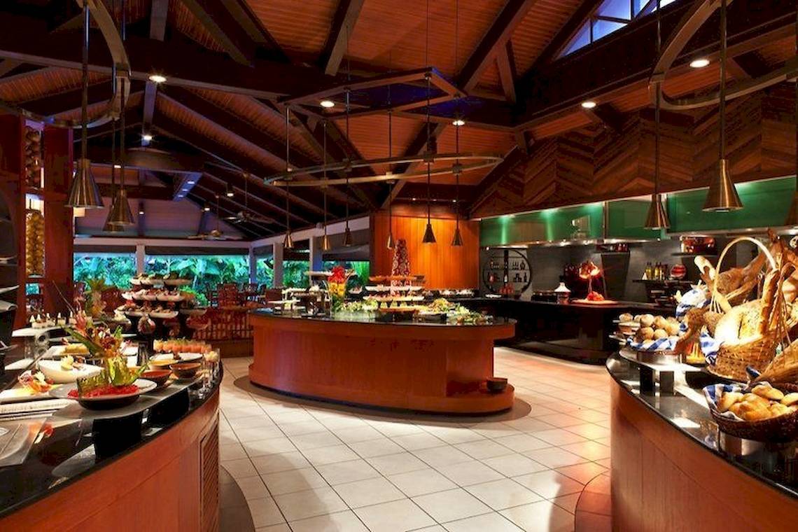 Buffetrestaurant im Sheraton Maldives Full Moon Resort & Spa mit vielen Speisen und einer offenen Küche.