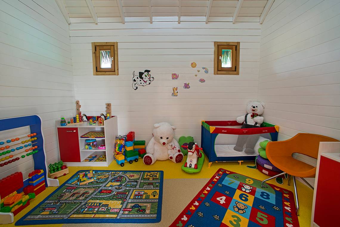 Ein Kinderzimmer mit Spielzeug, Teddybären und einem Spielmatratze im Aska Lara Resort & Spa.