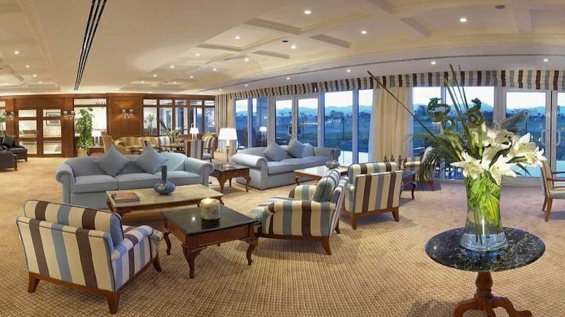 Wohnzimmer im Jolie Ville Golf & Resort mit Sofas, Tischen und einer Blumenvase.