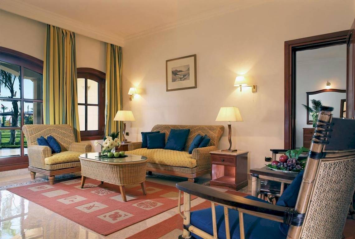 Wohnzimmer im Jolie Ville Golf & Resort mit Sofa, Stühlen, Tisch und Lampen.