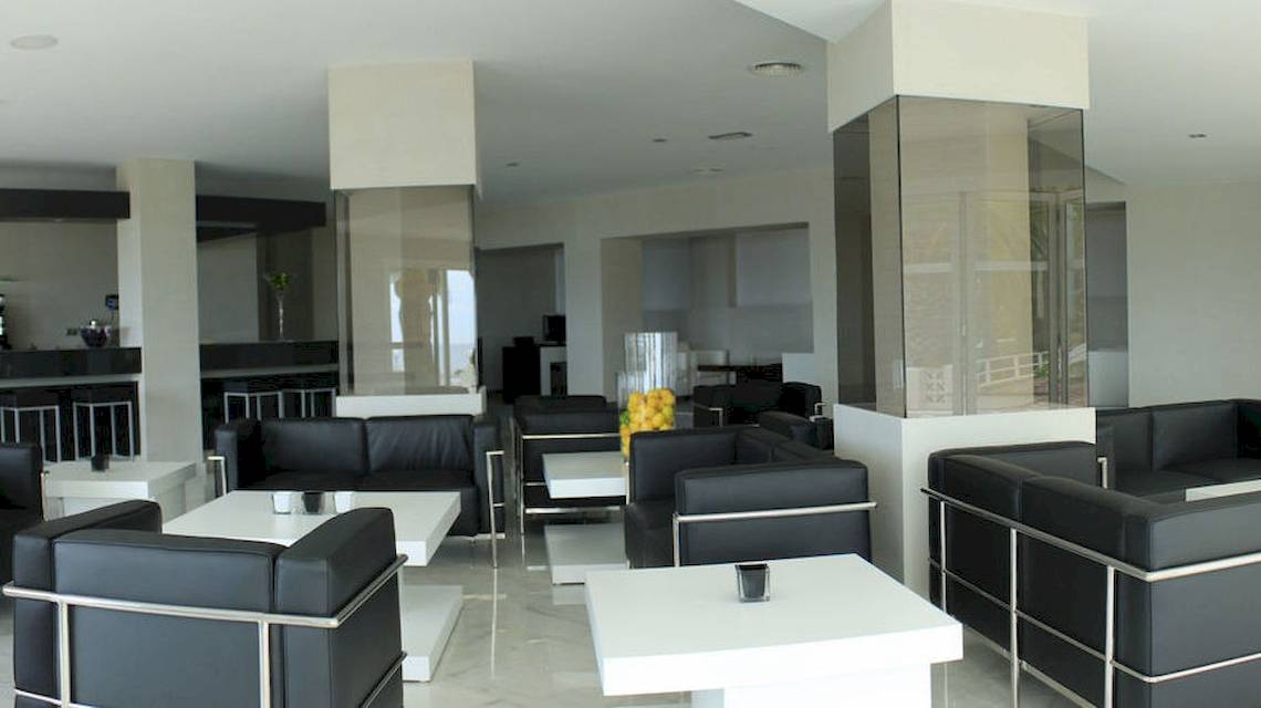 Lobby des BG Hotel Nautico Ebeso mit schwarzen Ledersofas und weißen Tischen