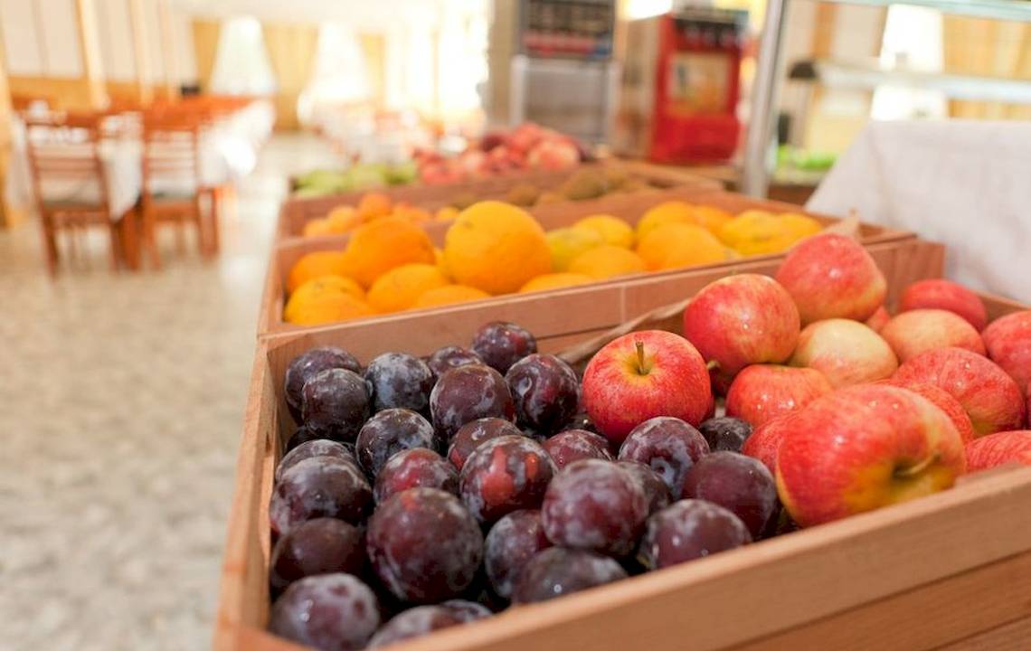 Frische Obstsorten in einem Restaurant im Hotel Moon Dreams Coral Beach. Äpfel und Pflaumen in Holzkisten.